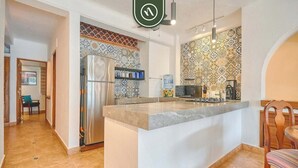 A modern kitchen with a central island, a refrigerator, a microwave, and a water dispenser. - Ocean View 1Br Condo-balcony-beach-pool - 606 (Puerto Vallarta)