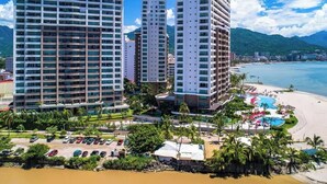 Un hotel de gran altura con varias plantas, playa y zona de piscina.