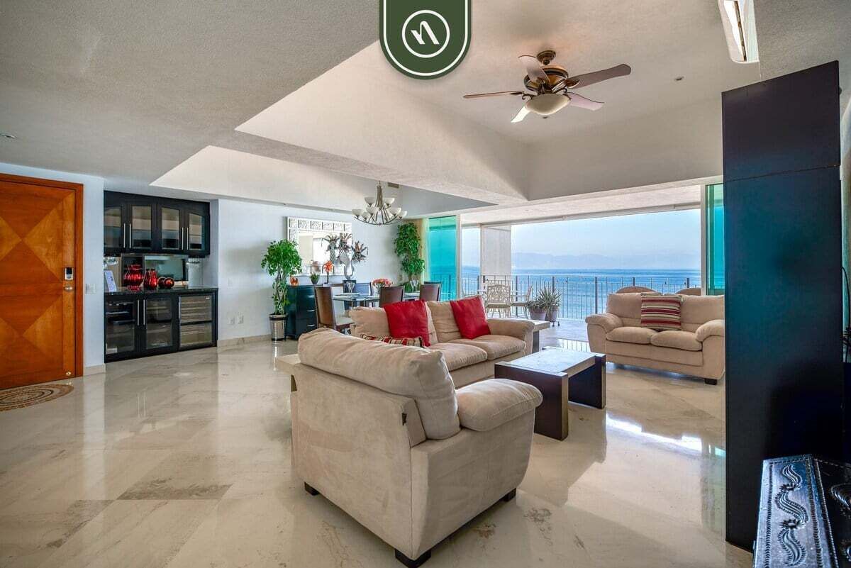 A spacious living area with a sofa, coffee table, and a view of the ocean.