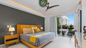 Un dormitorio moderno con una cama, mesitas de noche, ventilador de techo y vistas al exterior.