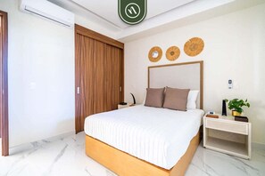 Une chambre à coucher avec un lit, une armoire en bois, une table de chevet avec une plante et des éléments de décoration murale.