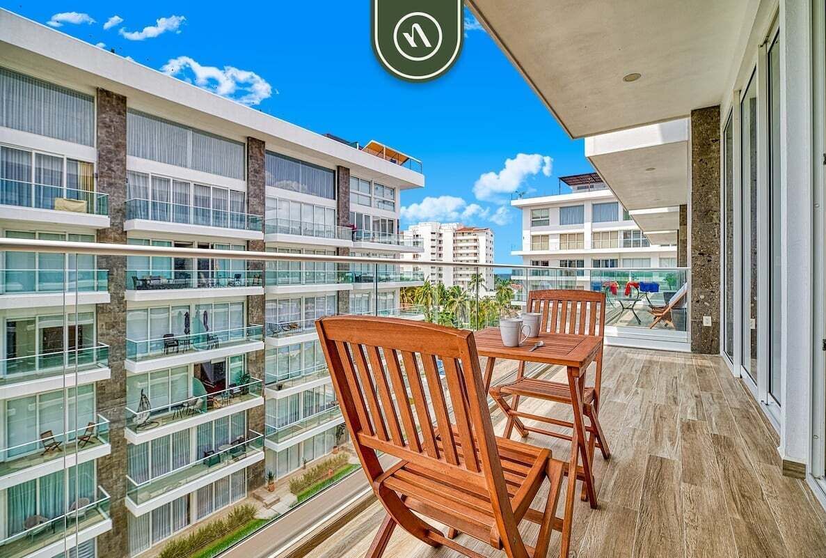 Un moderno edificio de apartamentos con varios balcones, ventanas amplias y una vista despejada del entorno.
