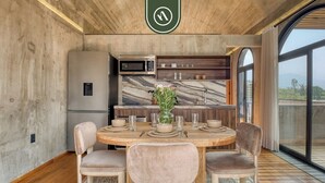 A modern kitchen with a marble backsplash, a dining area with a round table and chairs, and a large window offering a view. - Luxury 3 BR House in Downtown - AC - Peaceful (Oaxaca)