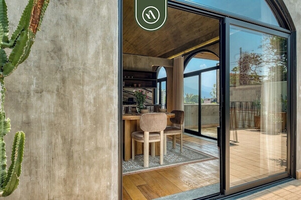 A modern interior with a dining area, a kitchen, and a large sliding glass door leading to an outdoor space.