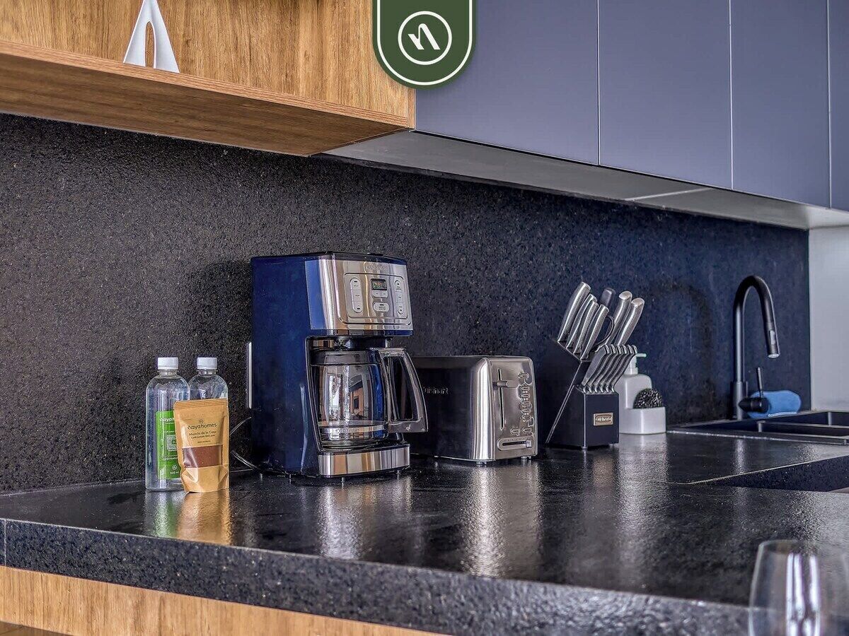 A kitchen with a coffee maker, toaster, and utensils on the counter.