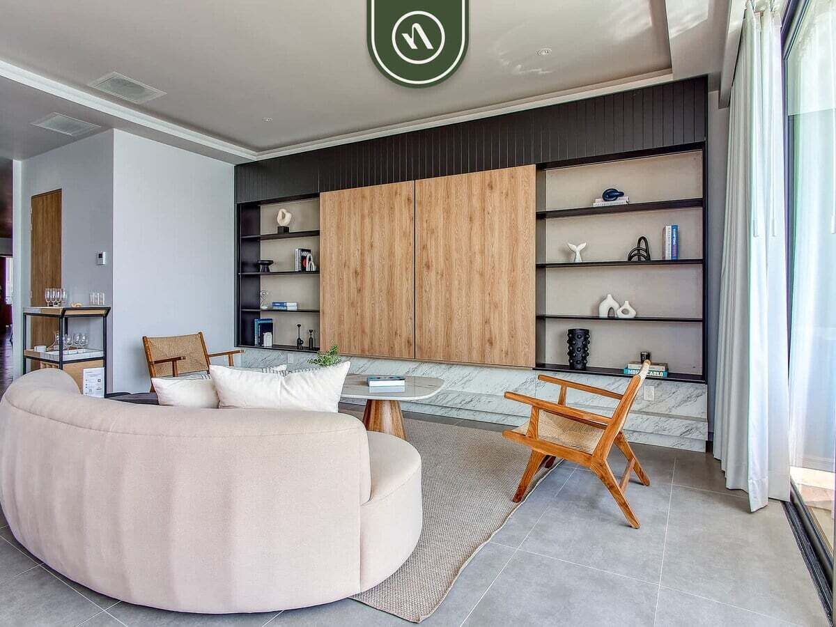 Una sala de estar moderna con un sofá grande, una mesa de centro de madera y una estantería.