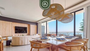 A modern dining area with a large table, wicker chairs, and a view of the ocean. - Luxury Oceanfront 3 BR Condo With Balcony (La Cruz de Huanacaxtle)
