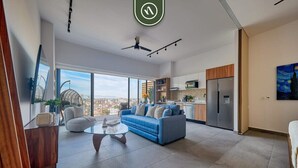Een moderne woonkamer met een bank, salontafel en uitzicht op de stad.