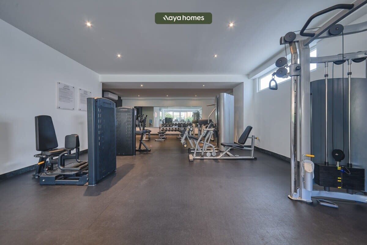Une salle de sport équipée de matériel d’exercice, d’un tapis de course et d’un banc de musculation.