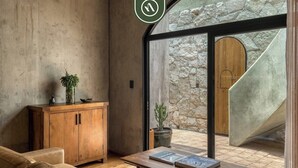 Un intérieur moderne avec un mur en pierre, une porte en bois et une vue sur un espace extérieur.