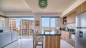 Een moderne keuken met een centraal eiland, houten kasten en een roestvrijstalen koelkast.