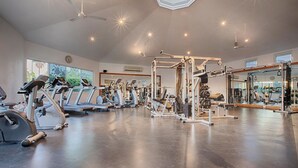 Ein Fitnessstudio mit Laufbändern, Crosstrainern und Gewichten.