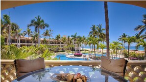 Ein Resort mit Pool, Palmen und Blick aufs Meer.