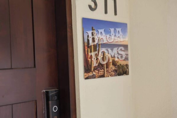 Une porte portant le numéro « 311 » et une affiche sur laquelle on peut lire « Bona Fortuna ».