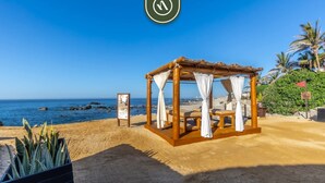 A beach cabana with a view of the ocean, a signboard, and a potted plant. - Three Bdrm Villa With Private Pool in Cabo - Sport Areas (Cabo San Lucas)