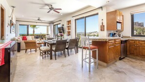 A spacious kitchen with a dining area, large windows, and a view of the outdoors. - New 2 BR Condo in San Jose - Pool - Tennis (San José del Cabo)