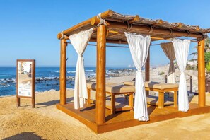 A beachside gazebo with four cushioned benches, a wooden structure, and a view of the ocean. - Two Bdrm House With Ocean View in Cabo (Cabo San Lucas)