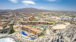 A resort with multiple buildings, a swimming pool, and a beach.
