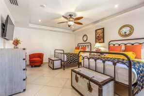 A bedroom with a bed, two bedside tables, a chair, a TV, a ceiling fan, and a wall-mounted mirror. - Two Bdrm House With Ocean View in Cabo (Cabo San Lucas)