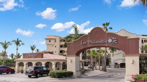 Entrada de un hotel con un cartel que dice 'Las Mananitas' y un cartel de 'Casago'.