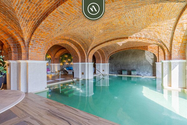 An indoor swimming pool with arched brick ceilings and a clear water surface. - Great Condo With Private Balcony - Ocean View (Cabo San Lucas)