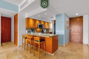 Una cocina moderna con una isla central, armarios de madera y un horno de acero inoxidable.