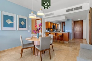 Una sala moderna con una mesa de comedor, sillas y una cocina al fondo.