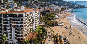 A coastal hotel with multiple balconies, a beach, and a pier. - Ocean View 2Br Condo-balcony-beach-pool - 610 (Puerto Vallarta)