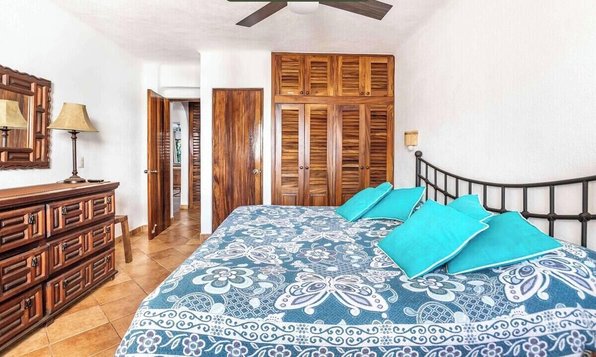 Une chambre à coucher avec un lit, une armoire en bois et une commode.