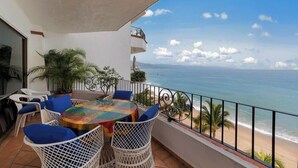 A balcony with a table and chairs, a view of the ocean, and a railing. - Ocean View 2Br Condo-balcony-beach-pool 710 (Puerto Vallarta)