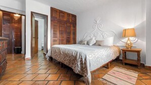 A bedroom with a bed, wooden shutters, a nightstand, and a lamp. - Ocean View 2Br Condo-balcony-beach-pool 710 (Puerto Vallarta)