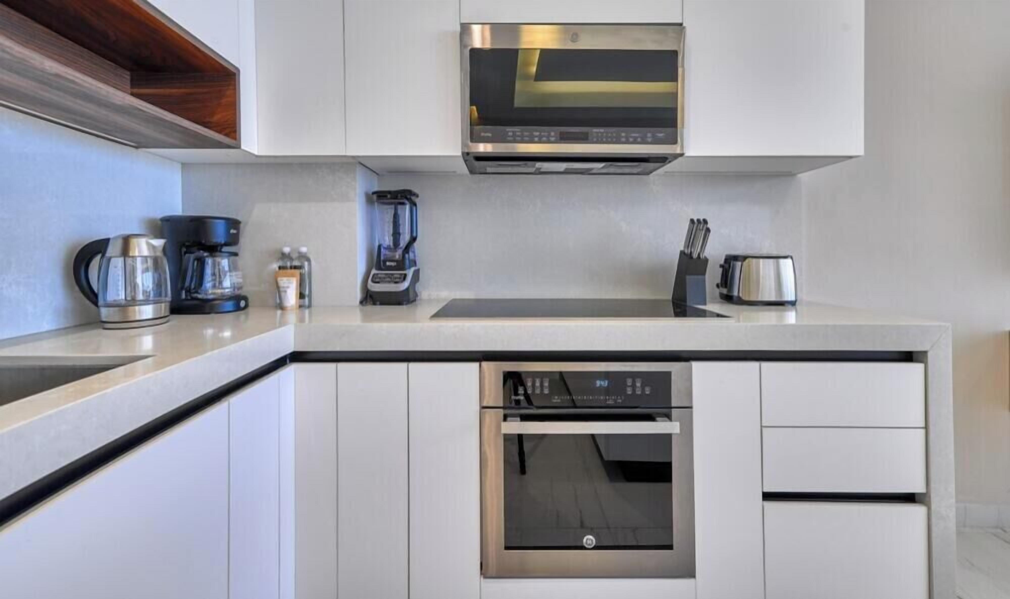 Eine moderne Küche mit Einbau-Mikrowelle, Kaffeemaschine, Toaster und Geschirrspüler.