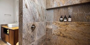 A bathroom with a marble wall, a sink, and three bottles on a shelf. - Equipped 3BR House - Pool - Gym - 5 min to Beach (Nuevo Nayarit)
