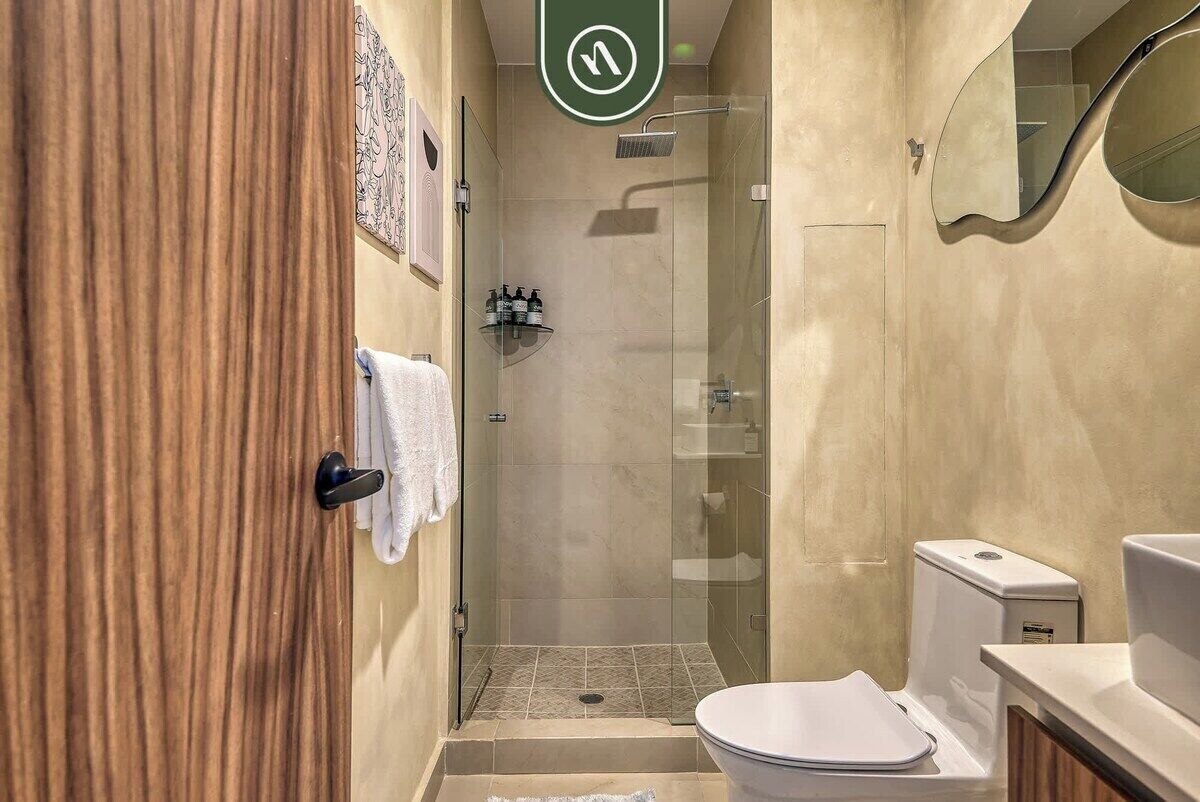 Une salle de bain moderne avec une douche à parois de verre, des toilettes et un lavabo.