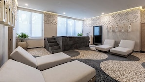 A modern spa room with a reception desk, lounge chairs, a staircase, and decorative wall patterns. - Udara Udara 2K (Bucerías)