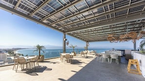 A rooftop terrace with outdoor seating, a view of the sea, and a glass ceiling. - Udara Udara 2K (Bucerías)