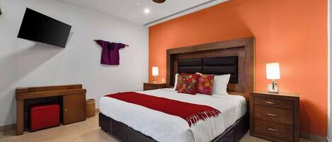 A bedroom with a bed, nightstands, a TV, a ceiling fan, and a red bench.
