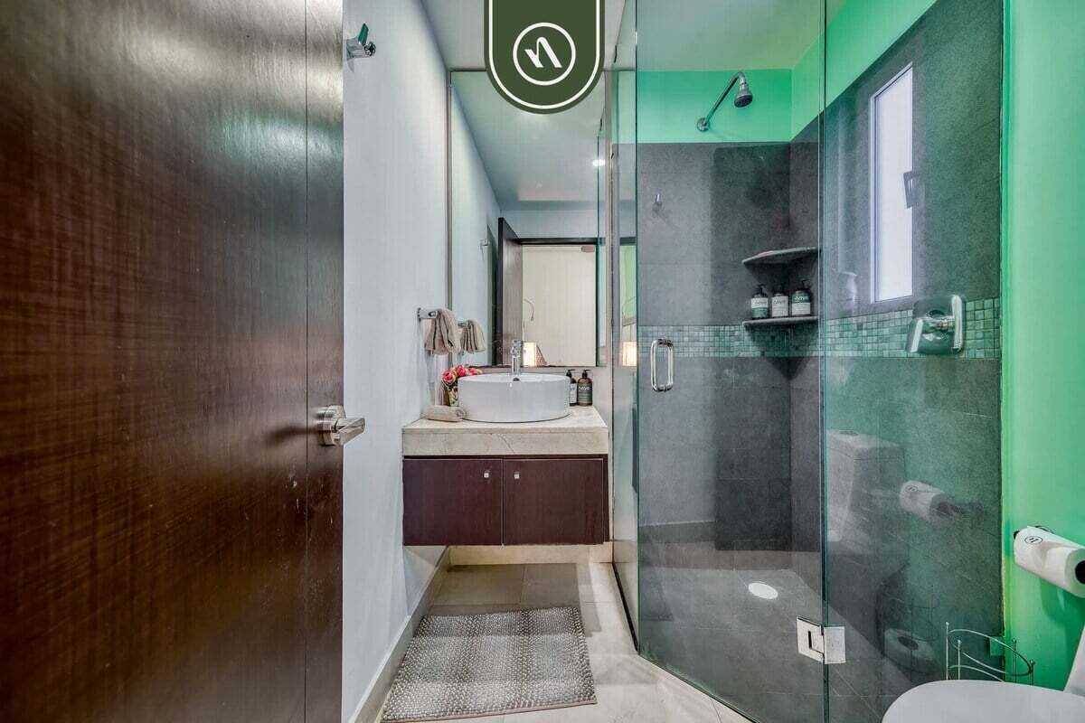 Une salle de bain moderne avec une douche à parois de verre, un meuble-lavabo et un miroir.