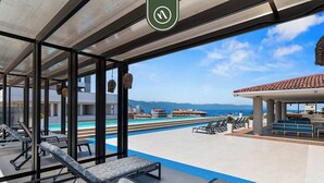 A rooftop pool area with lounge chairs, a view of the ocean, and a clear sky. - Beautiful 2 BR Condo Amazing Rooftop Pool - Gym (Puerto Vallarta)
