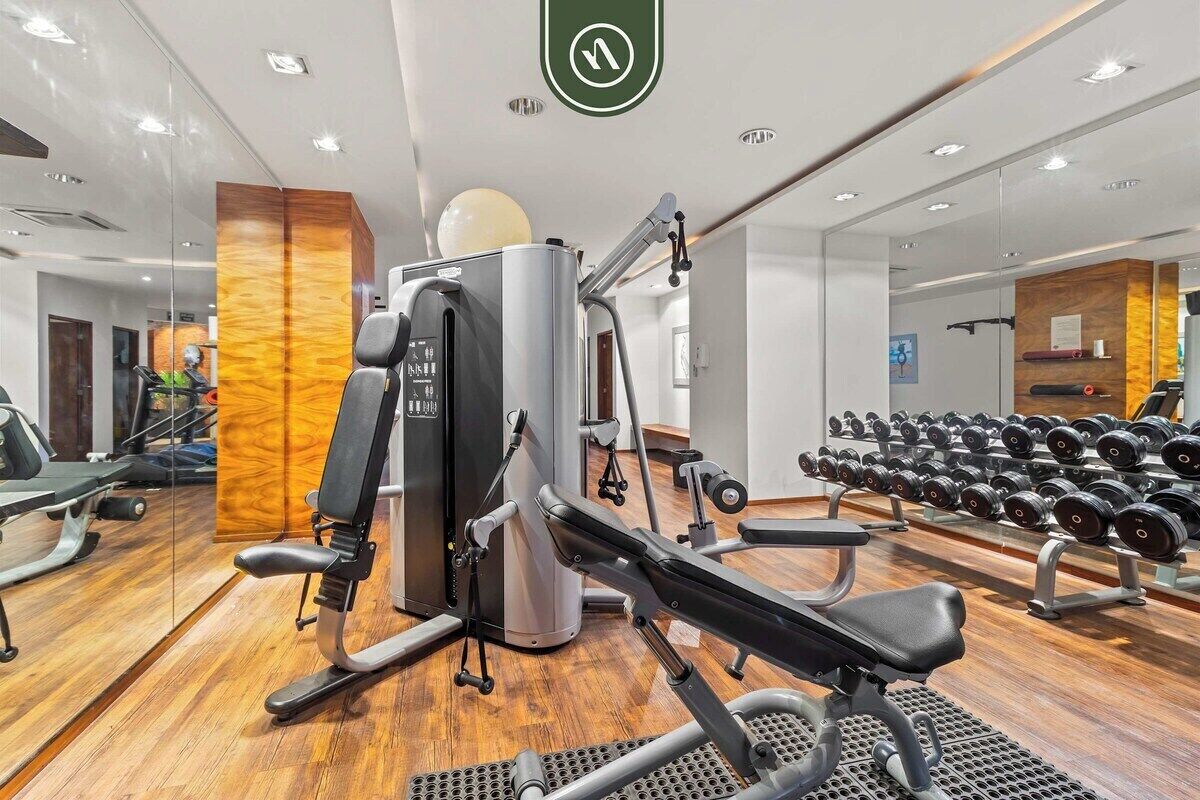 A gym with exercise equipment, a mirror, and a wall with a wooden panel.