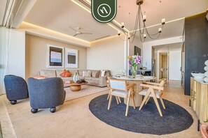 A modern living room with a round dining table, two sofas, and a coffee table.