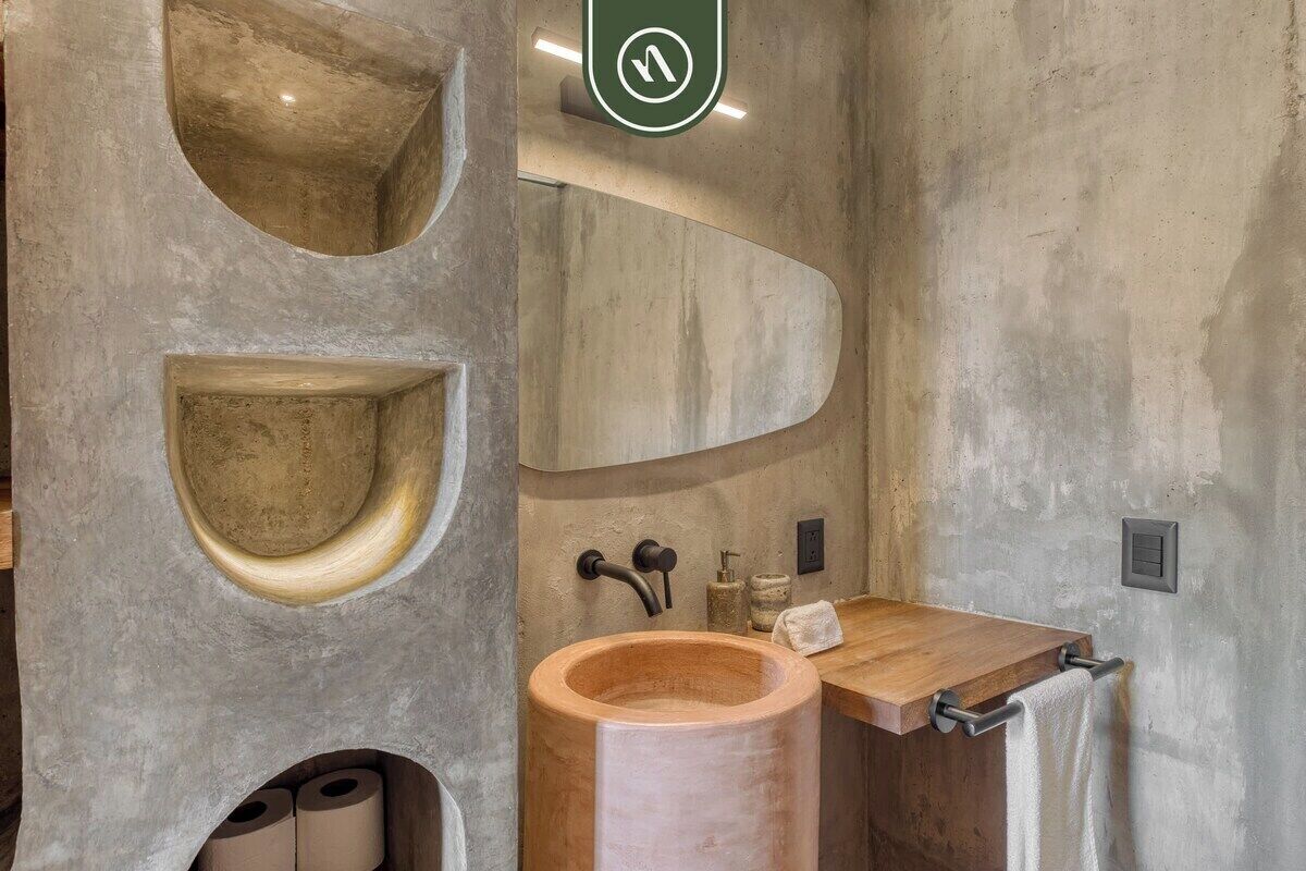Une salle de bain avec un grand lavabo en bois, un miroir et un porte-serviettes.