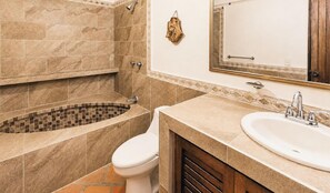 Ein Badezimmer mit Badewanne, Toilette, Waschbecken und Spiegel.