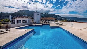 A rooftop swimming pool with a view of mountains and buildings. - Ocean View 2Br Condo-balcony-beach-pool - 206 (Puerto Vallarta)