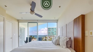 A bedroom with a large bed, a ceiling fan, a view of the ocean, and a balcony. - Oceanview 2 BR Condo - Beachclub - Pool - Ocean (Nuevo Nayarit)