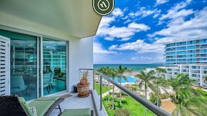 A balcony with a view of the ocean, a pool, and a hotel building. - Oceanview 2 BR Condo - Beachclub - Pool - Ocean (Nuevo Nayarit)