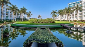 A hotel with a pool, palm trees, and a well-maintained lawn. - Oceanview 2 BR Condo - Beachclub - Pool - Ocean (Nuevo Nayarit)