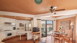 A spacious living area with a kitchen, dining table, and a balcony with outdoor seating. - Amazing 2 BR Condo - Partial Oceanview - Pool (Puerto Vallarta)