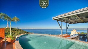 Una piscina amb vistes a l'oceà i una palmera.