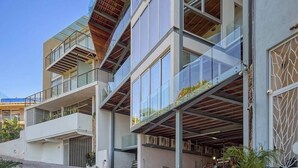 Un immeuble à plusieurs étages doté de balcons, de grandes fenêtres et d’un espace de garage.